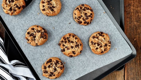 Freshly baked cookies on a commercial baking tray with non-stick baking liner