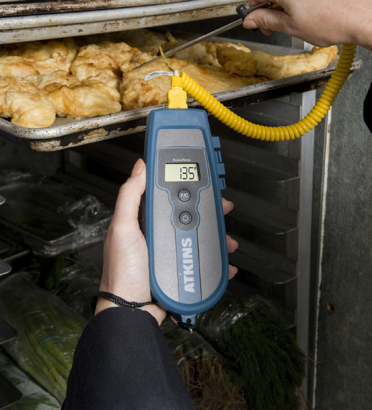 thermometer probe measuring chicken temperature in an oven